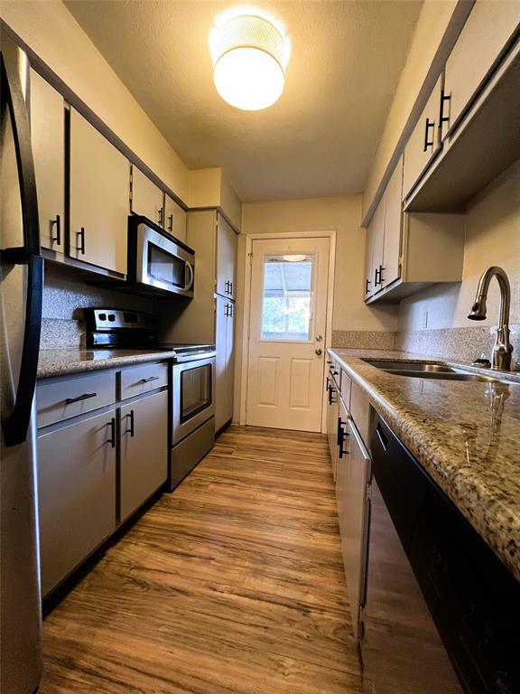 a kitchen with stainless steel appliances granite countertop a sink stove and oven