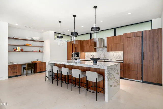 a kitchen with kitchen island a dining table chairs and white cabinets