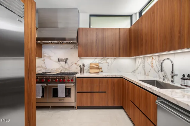 a kitchen with stainless steel appliances granite countertop a sink and a stove