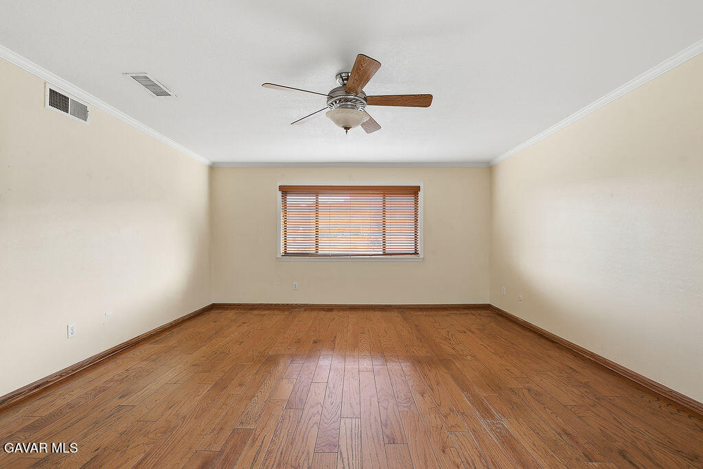 711 Lisa Street Palmdale, CA 93551 - Photo 14 of 66 an empty room with wooden floor windows and ceiling fan