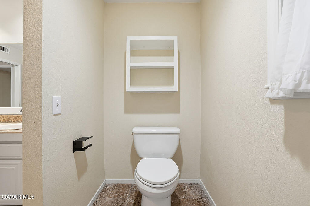 711 Lisa Street Palmdale, CA 93551 - Photo 20 of 66 a white toilet sitting in a bathroom next to a window