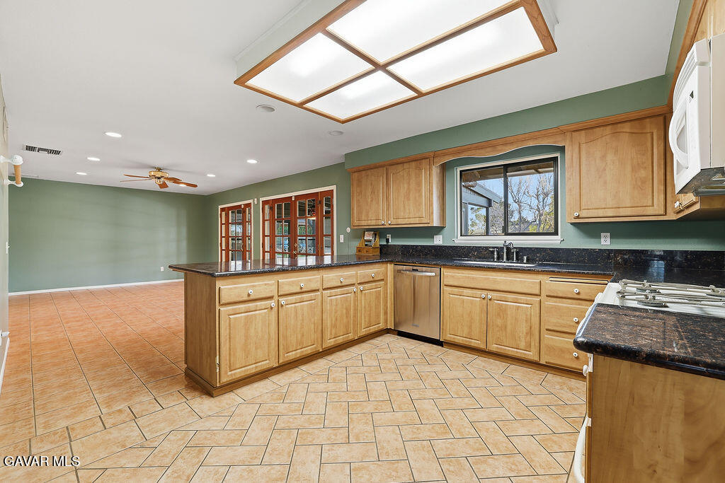 711 Lisa Street Palmdale, CA 93551 - Photo 30 of 66 a kitchen with stainless steel appliances granite countertop a stove a sink and a microwave