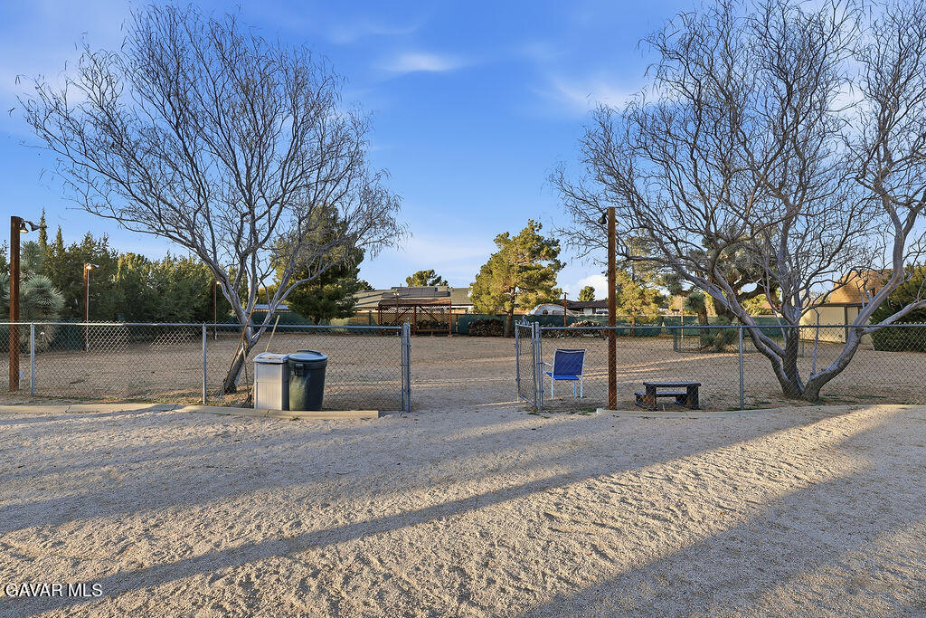 711 Lisa Street Palmdale, CA 93551 - Photo 38 of 66 a backyard of a house with large trees and outdoor seating