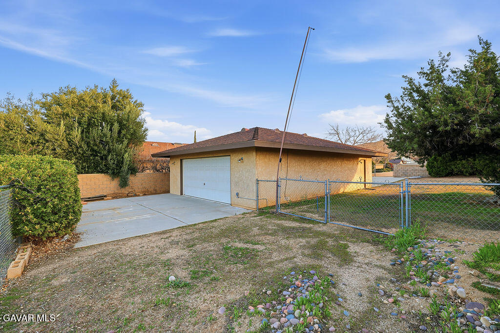 711 Lisa Street Palmdale, CA 93551 - Photo 43 of 66 a yellow house with trees in front of it