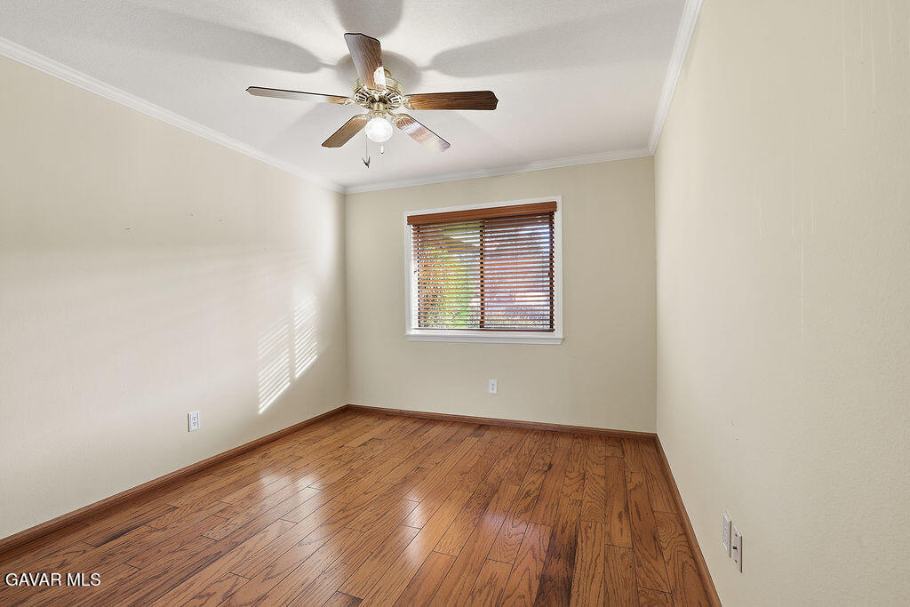 711 Lisa Street Palmdale, CA 93551 - Photo 6 of 66 an empty room with wooden floor chandelier fan and windows