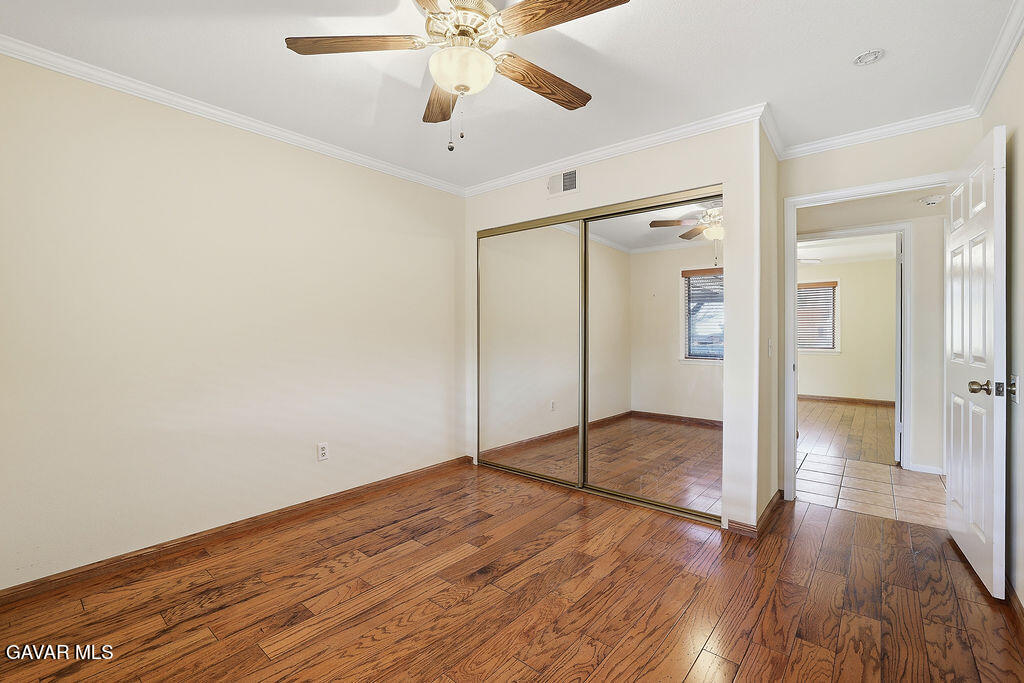 711 Lisa Street Palmdale, CA 93551 - Photo 9 of 66 an empty room with wooden floor fan and windows