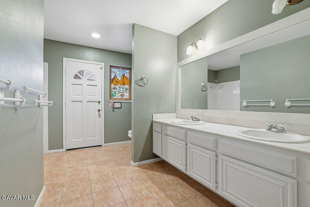 711 Lisa Street Palmdale, CA 93551 - Photo 10 of 66 a spacious bathroom with a double vanity sink and a mirror