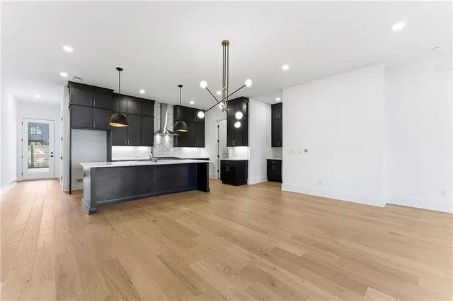a view of large kitchen with kitchen island a sink stainless steel appliances and cabinets