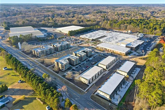 an aerial view of a city with lots of residential buildings and mountain view in back
