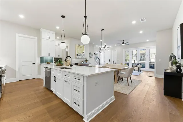 a large kitchen with kitchen island a sink a center island a stove a dining table and chairs
