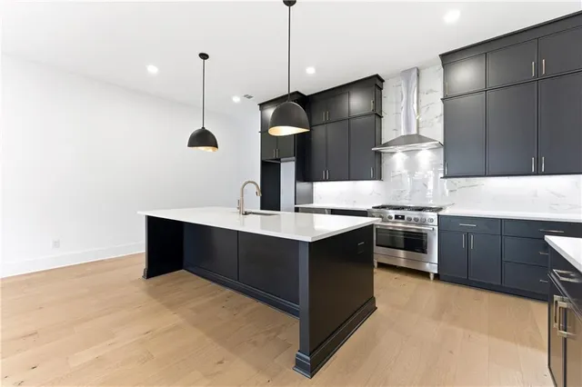 a kitchen with stainless steel appliances granite countertop a sink a stove and a refrigerator