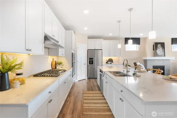 a kitchen with stainless steel appliances a sink a counter top space stove refrigerator and cabinets