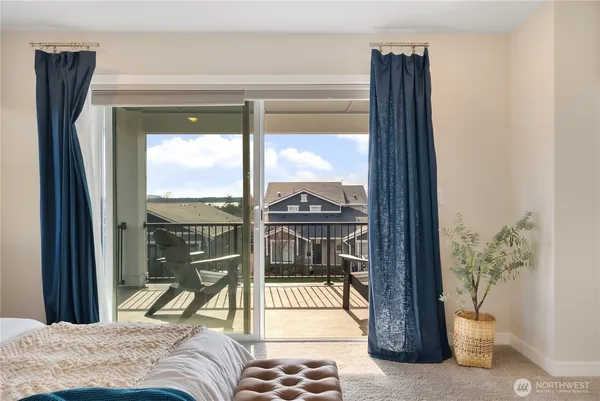 a view of a balcony with a bed and glass door