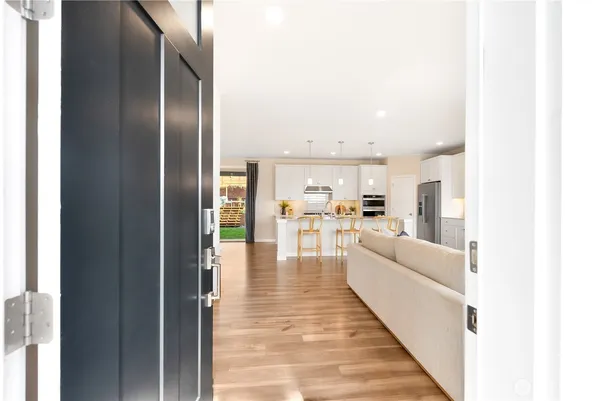 a large white kitchen with cabinets a sink and stainless steel appliances