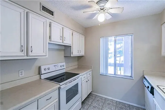 a kitchen with cabinets appliances and a window