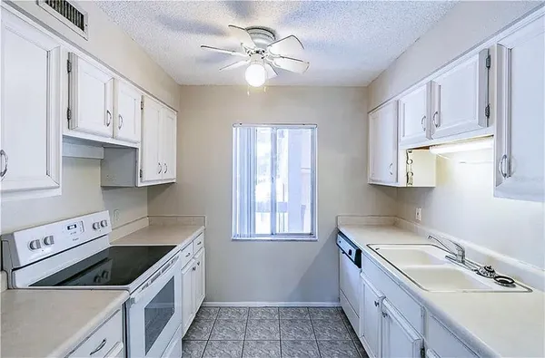 a kitchen with cabinets appliances a sink and a window