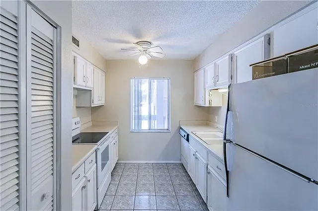 a kitchen with a refrigerator a sink and cabinets