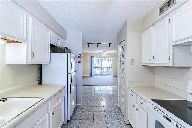 a kitchen with a sink a stove and cabinets