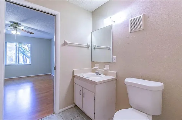 a bathroom with a toilet sink vanity and mirror