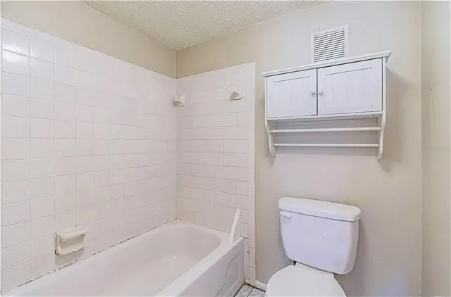 a white toilet sitting next to a bath tub