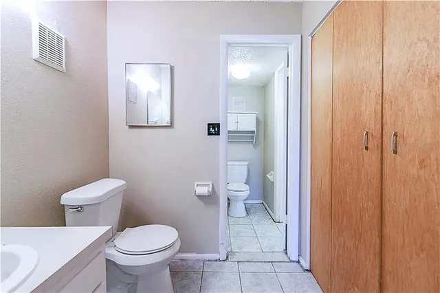 a white toilet sitting next to a bathroom sink