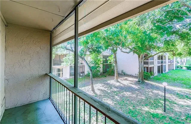 a view of a house with backyard and trees