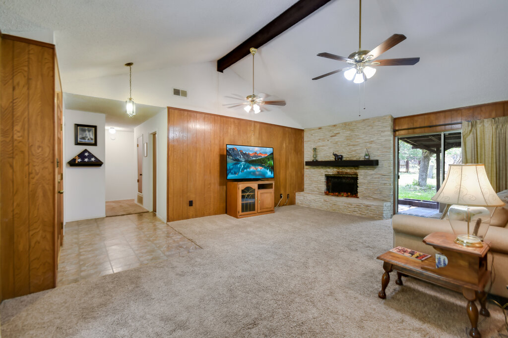 301 Navajo Trail Georgetown, TX 78633 - Photo 27 of 35 Living area featuring high vaulted ceiling, beam ceiling, ceiling fan, a fireplace, and carpet flooring