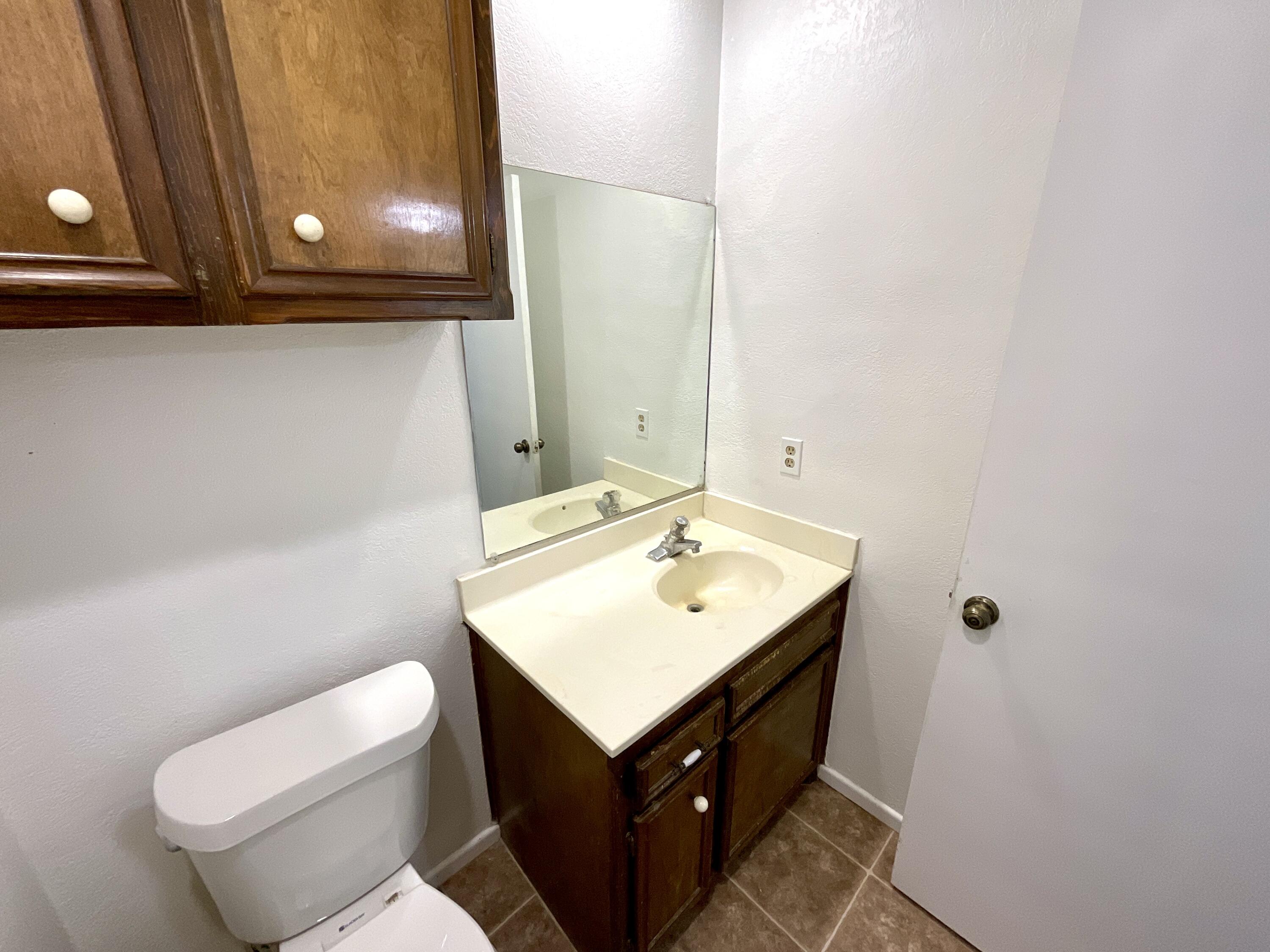 6108 37th Street, Unit B Lubbock, TX 79407 - Photo 2 of 8 a bathroom with a sink toilet and mirror