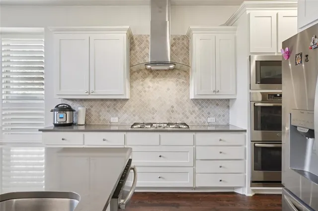 a kitchen with stainless steel appliances granite countertop a refrigerator and cabinets