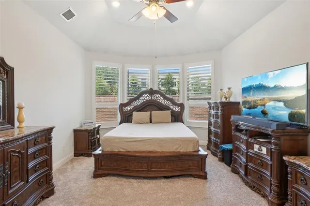 a spacious bedroom with a bed and a chandelier