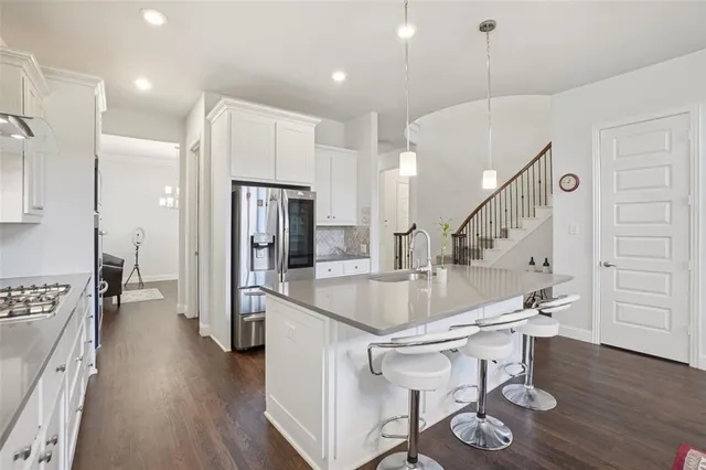 a kitchen with stainless steel appliances kitchen island a table and chairs