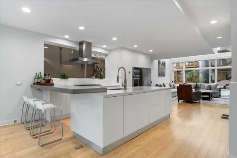 a large white kitchen with a large window and stainless steel appliances