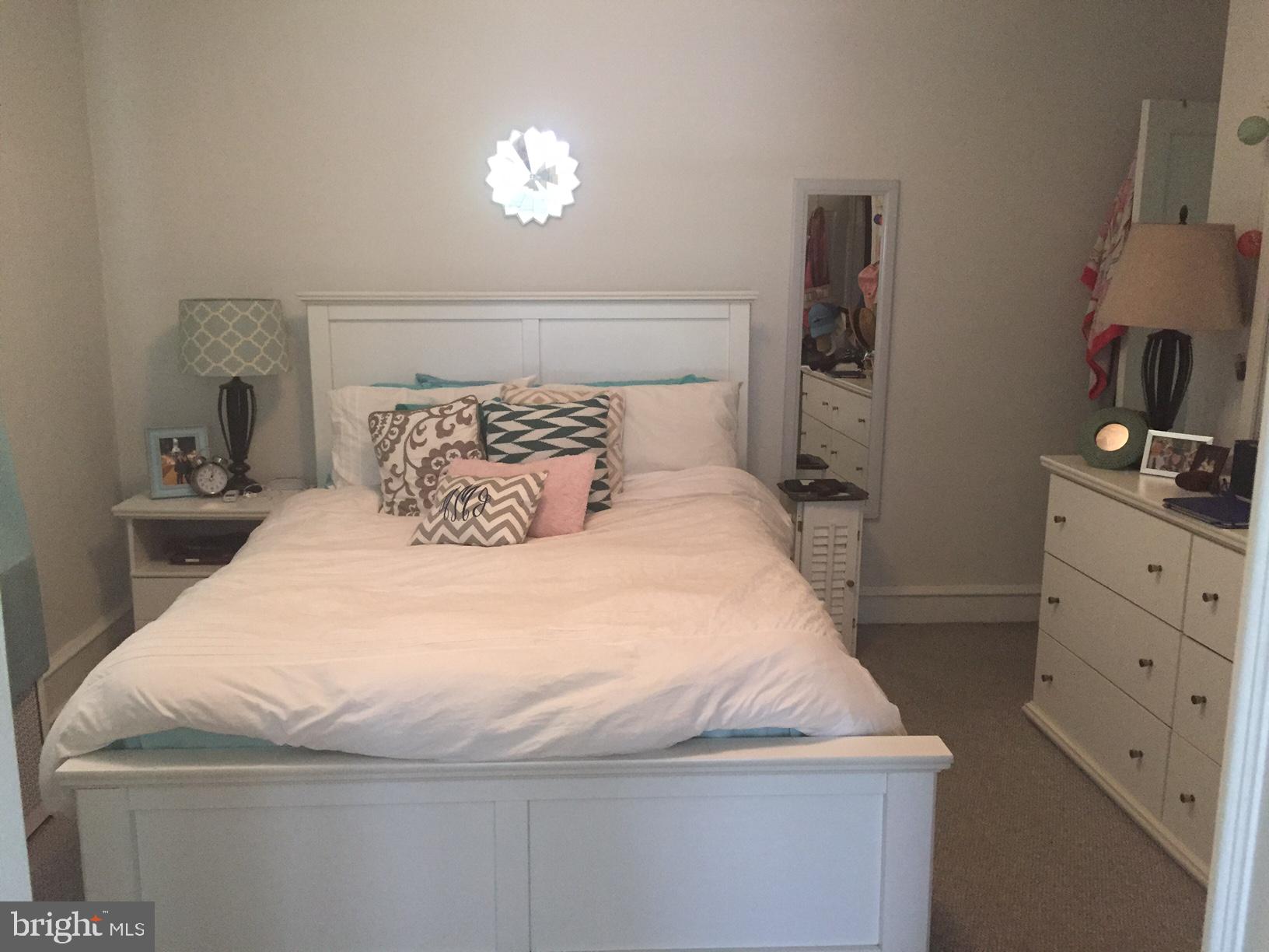 100 South Valley Road, Unit 1A Paoli, PA 19301 - Photo 7 of 11 a bedroom with a bed and a chandelier