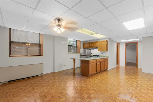 a kitchen with stainless steel appliances granite countertop a stove a sink dishwasher and a refrigerator with white cabinets