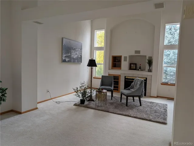 a living room with furniture a fireplace and a window