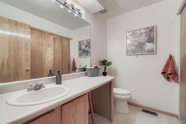 a bathroom with a toilet a sink and mirror