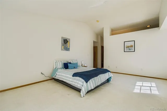 a spacious bedroom with a bed and a window