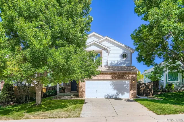 a front view of house with yard and trees