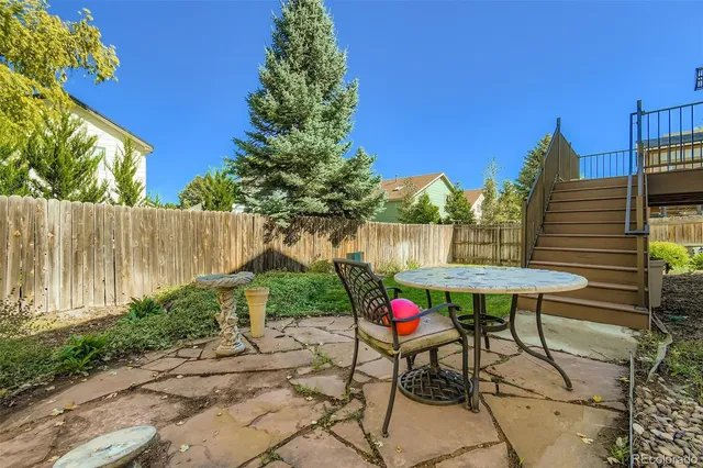 a view of a chairs and table in patio with a backyard