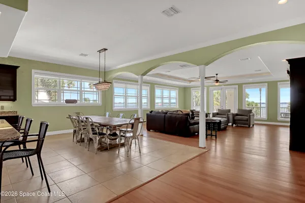 a kitchen with stainless steel appliances granite countertop a stove and a view of dining hall with couches