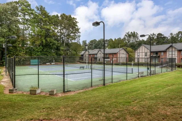 a view of a patio with table and chairs potted plants and a large tree