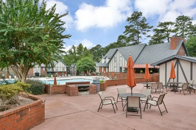 a view of a park that has a sign board large trees and plants