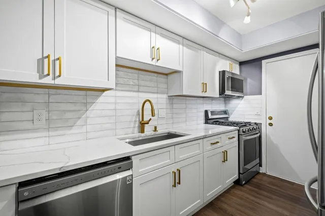 a kitchen with stainless steel appliances granite countertop a refrigerator and a sink
