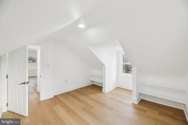 an empty room with wooden floor and entryway