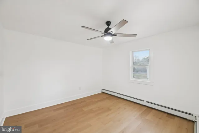an empty room with a window and a ceiling fan