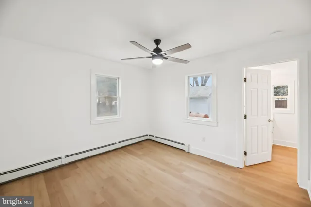 an empty room with fan and windows