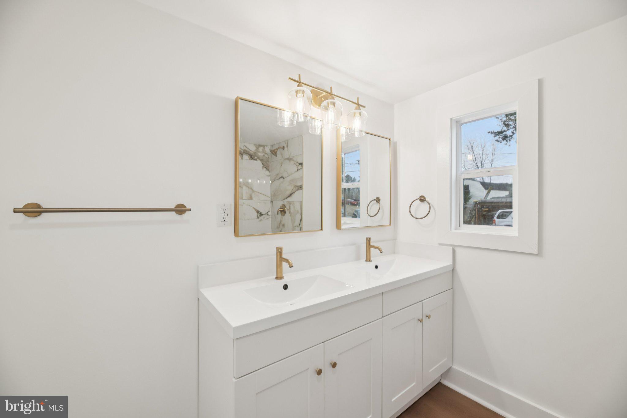 24399 Morgan Road Hollywood, MD 20636 - Photo 22 of 40 a bathroom with a double vanity sink and mirror