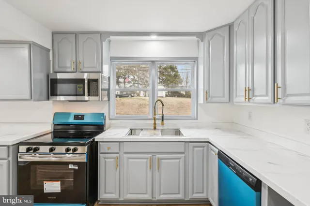 a kitchen with stainless steel appliances a stove sink and microwave