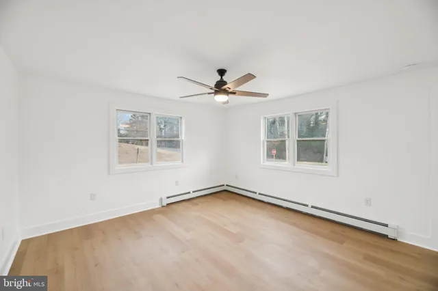 an empty room with window and ceiling fan