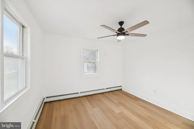 an empty room with a window and a fan